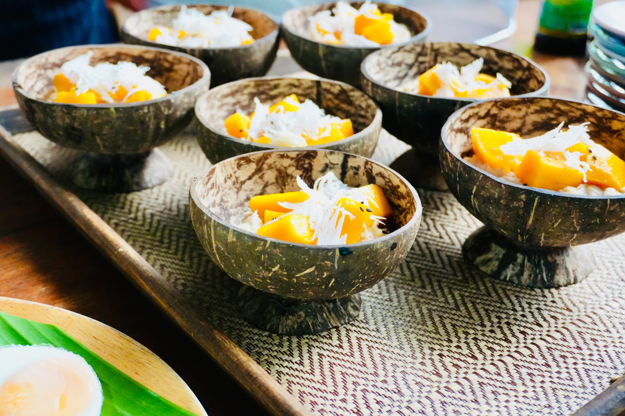 Fresh mango and coconut rice served in coconut bowls at True Nature