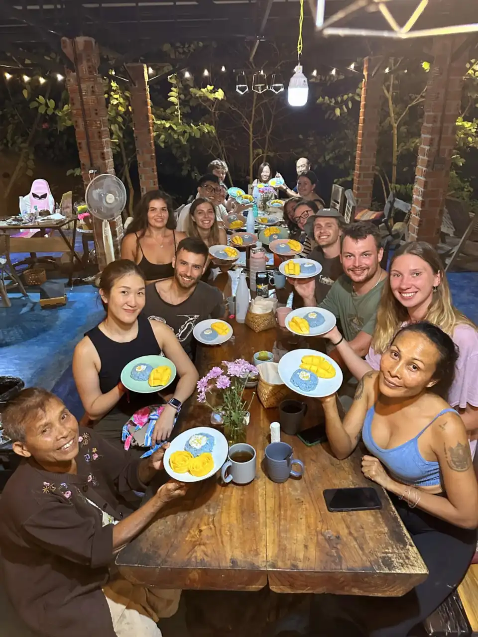 Guests at dinner under string lights