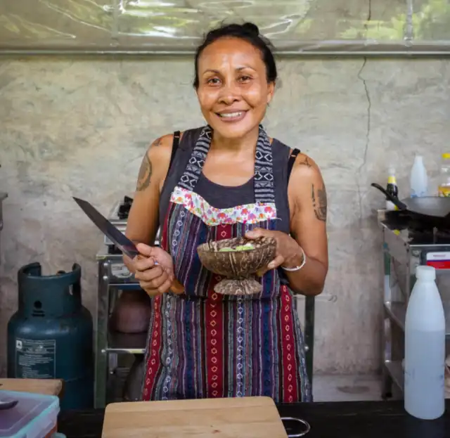 Ning smiling in the kitchen with a bowl of freshly made curry paste