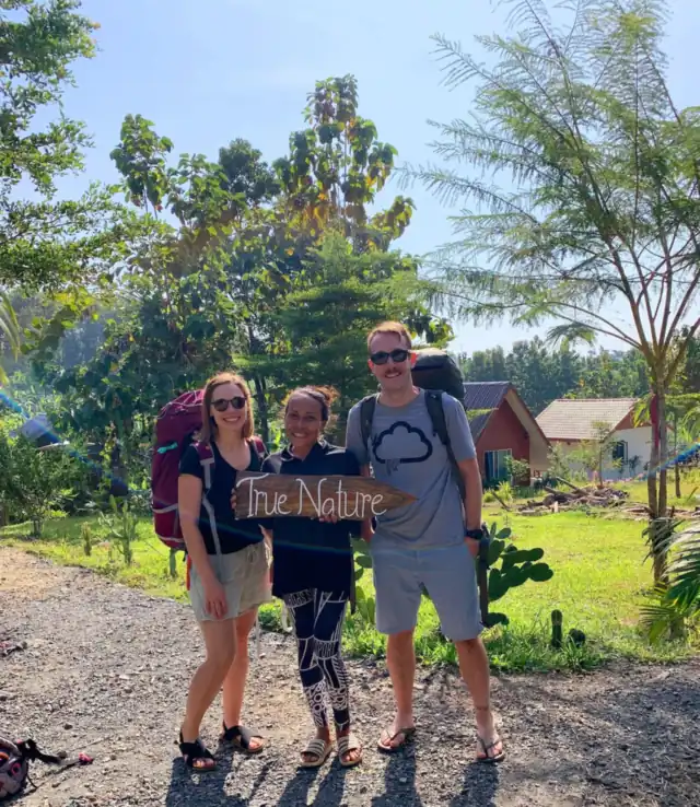 A family holding a welcome sign at the entrance