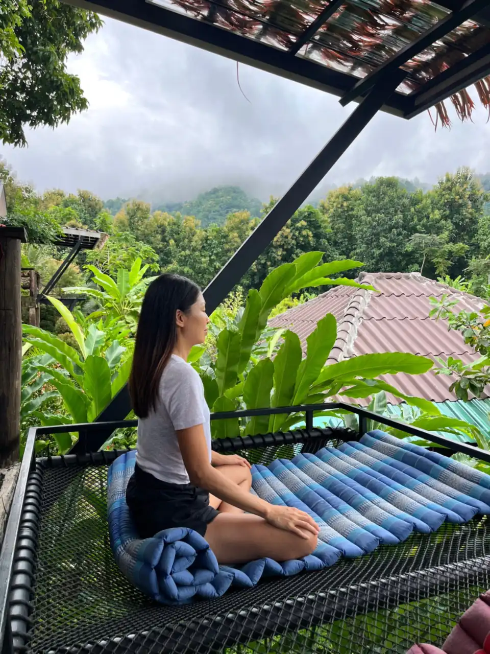A guest meditating on a net hammock overlooking the gardens