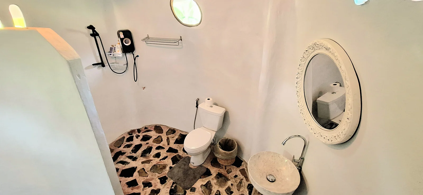 The private Mushroom House bathroom with a shower and stone floor