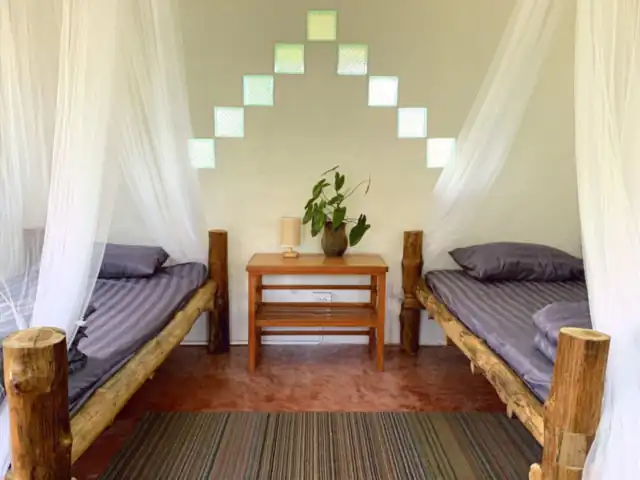 A bright twin room with two wooden single beds
