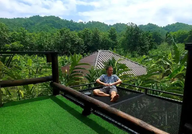 A guest relaxing on the Triangle House balcony net