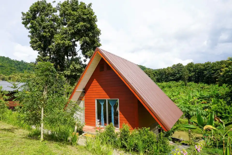 The Triangle House, a tall red A-frame house in the garden