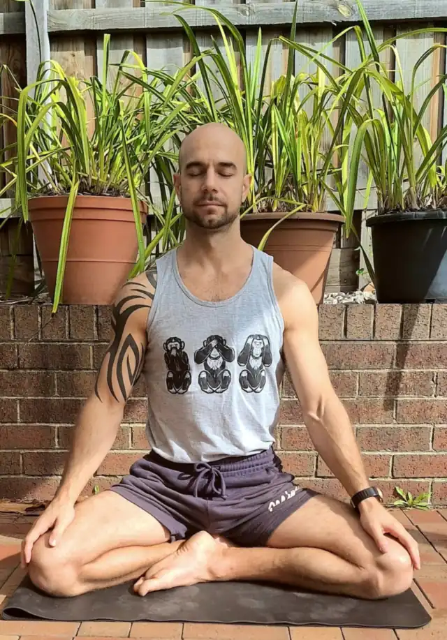Adam meditating cross-legged