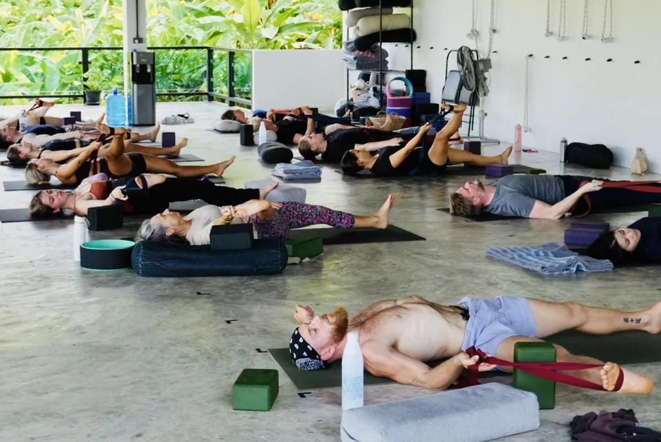 Guests resting in a gentle floor-based yoga practice in the True Nature shala