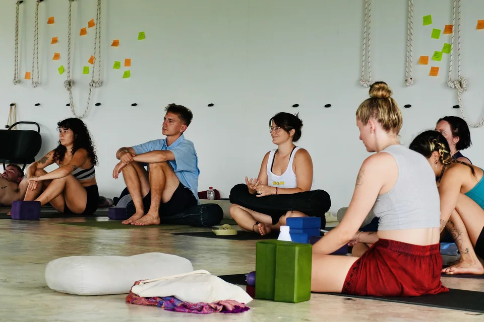 Teacher training students sitting together for a discussion in the open-air shala