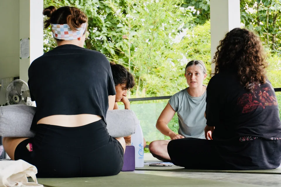 Teacher training students sharing a seated discussion in the shala