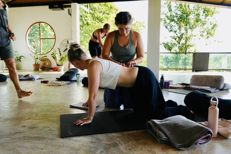 A teacher training student supporting a classmate during a practical lesson