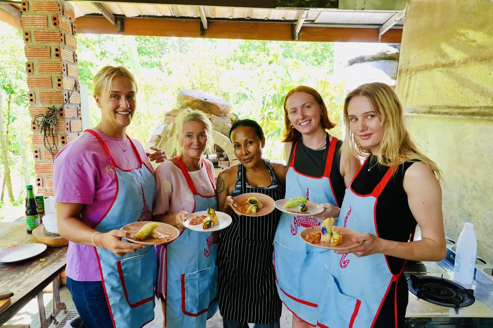 Guests holding the dishes they made together in Ning’s cooking class