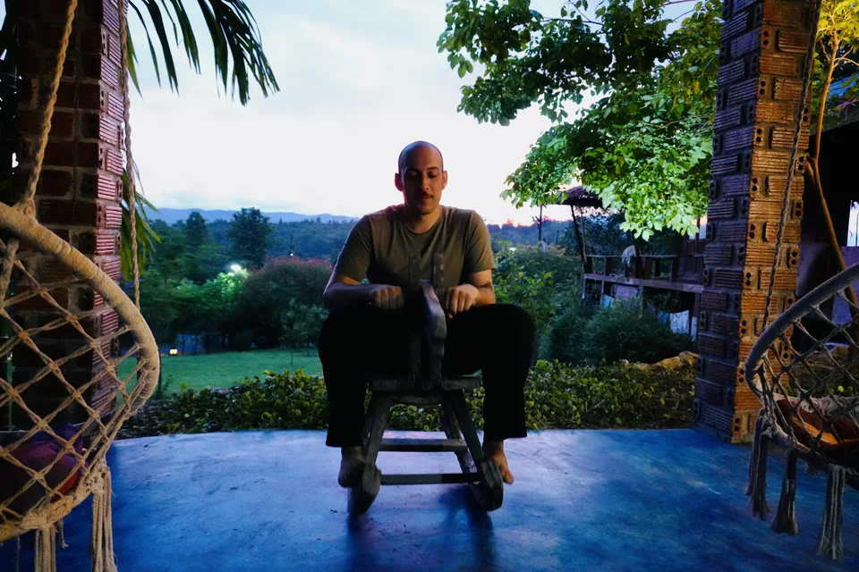 A guest resting in a wicker chair at dusk at True Nature