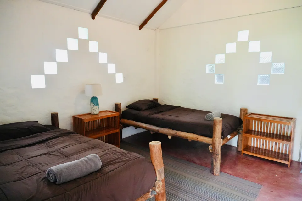 Two wooden single beds in a bright, simple True Nature retreat room