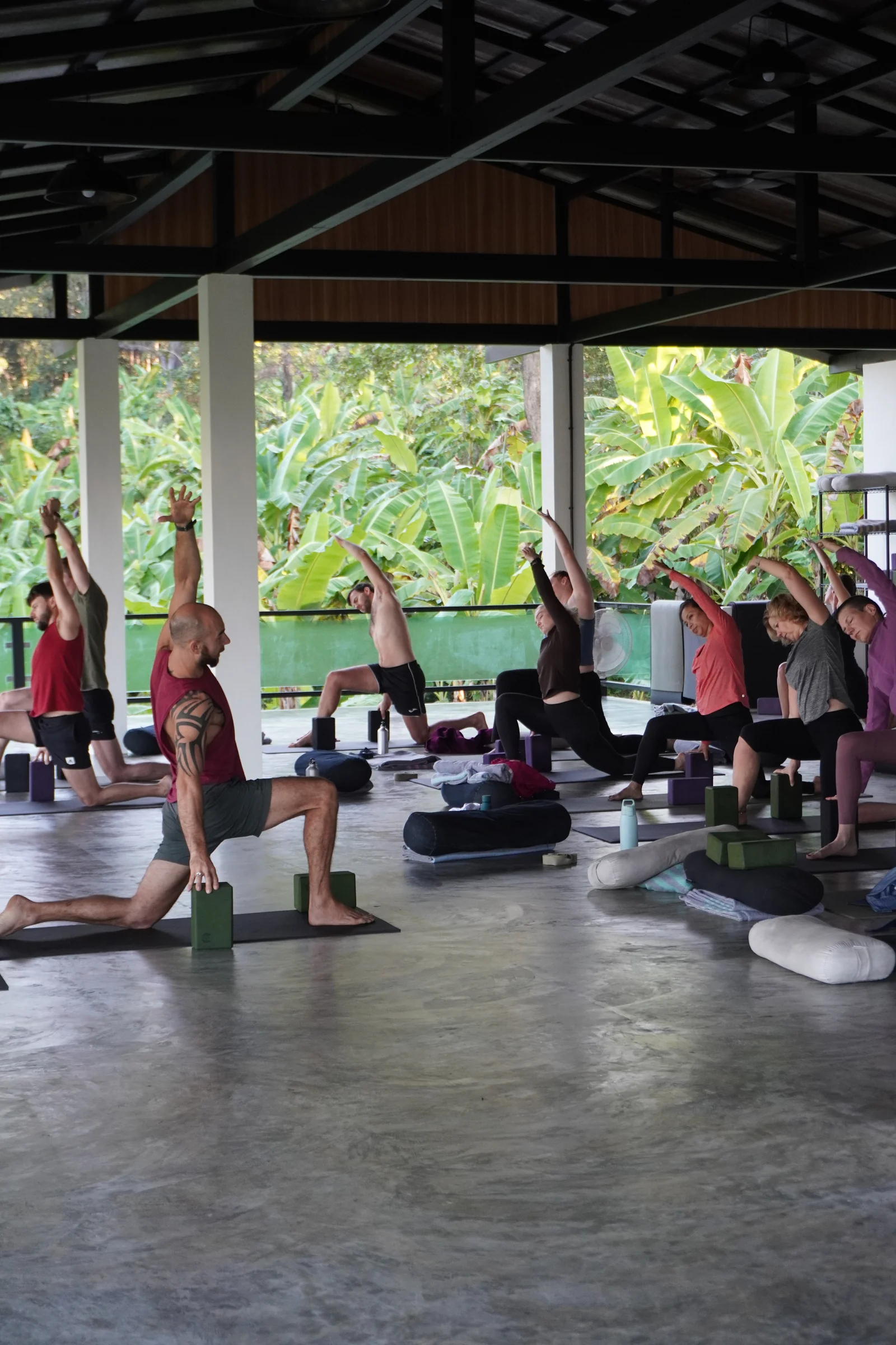 A small yoga class stretching in a supported low lunge