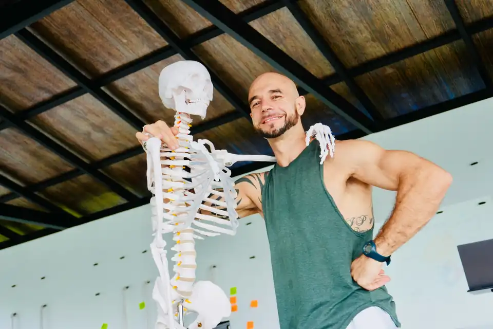 A teacher grinning beside the anatomy skeleton during the September 2026 training