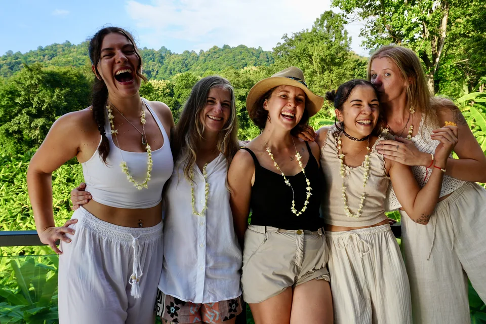 Smiling teacher training graduates celebrating together in the True Nature hills